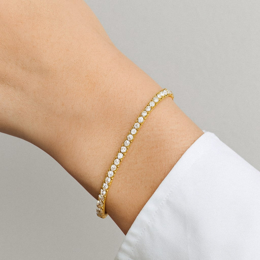Gold moissanite tennis bracelet worn on the wrist
