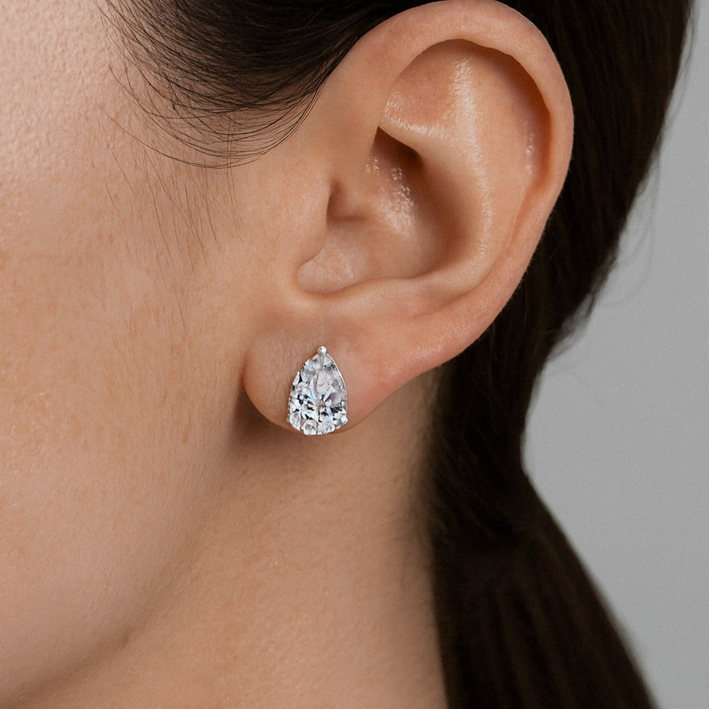 Pear Moissanite Stud Earrings in 925 Sterling Silver, worn on model for scale