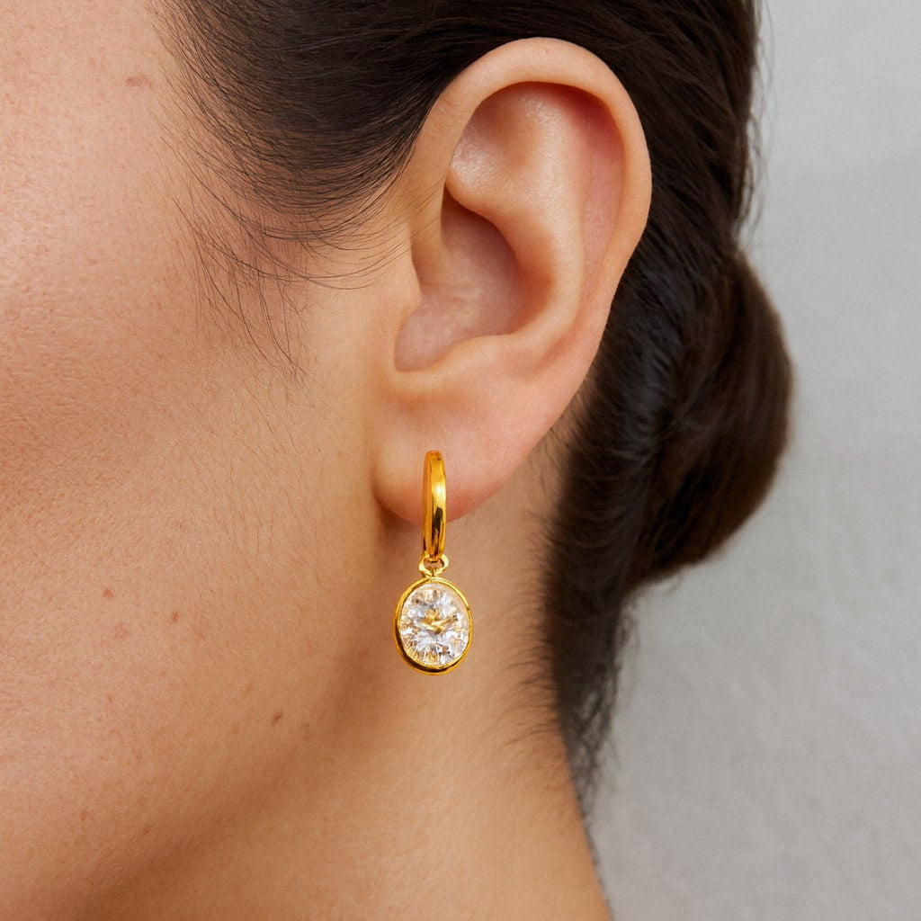 Oval Moissanite Drop Earrings, Gold Huggie Hoops in 18k Gold Plated Sterling Silver, worn on model for scale