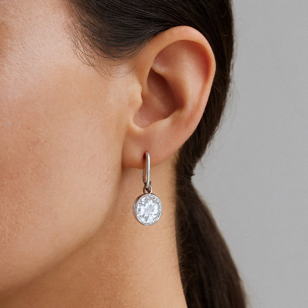Oval Moissanite Drop Earrings, Silver Huggie Hoops in 925 Sterling Silver, worn on model for scale