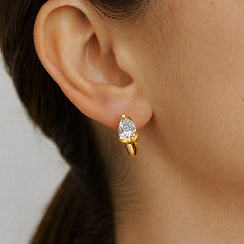 Gold Pear Moissanite Huggie Earrings, 18k Gold Plated Sterling Silver, worn on model for scale