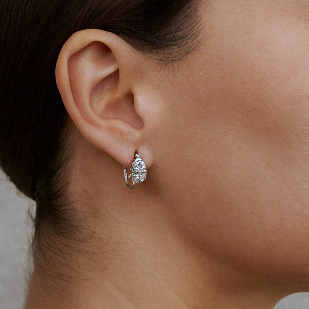 Oval Moissanite Huggie Earrings, 925 Sterling Silver, worn on model for scale