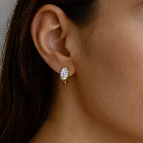 Gold Oval Moissanite Huggie Earrings, 18k Gold Plated Sterling Silver, worn on model for scale